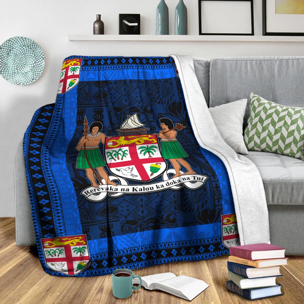 Blue and navy blanket on sofa with white throw; crest and dancer scene in center