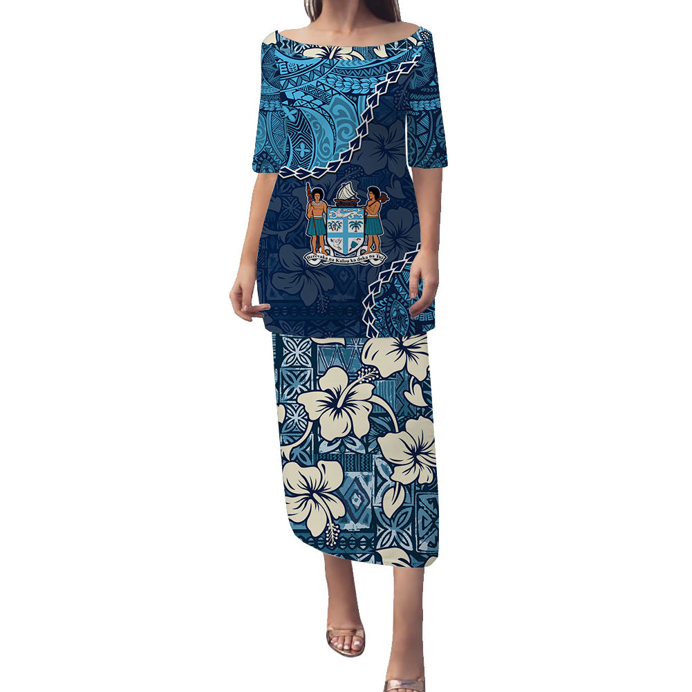 Blue long dress with 3/4 sleeves, off-shoulder neckline, and tapa-style floral pattern