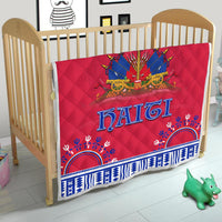 Red quilt with Haiti lettering and blue geometric trim, shown on baby bed