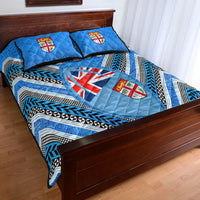 Blue quilt bed set with Fiji crest center, black-and-white zigzag bands, two blue pillows