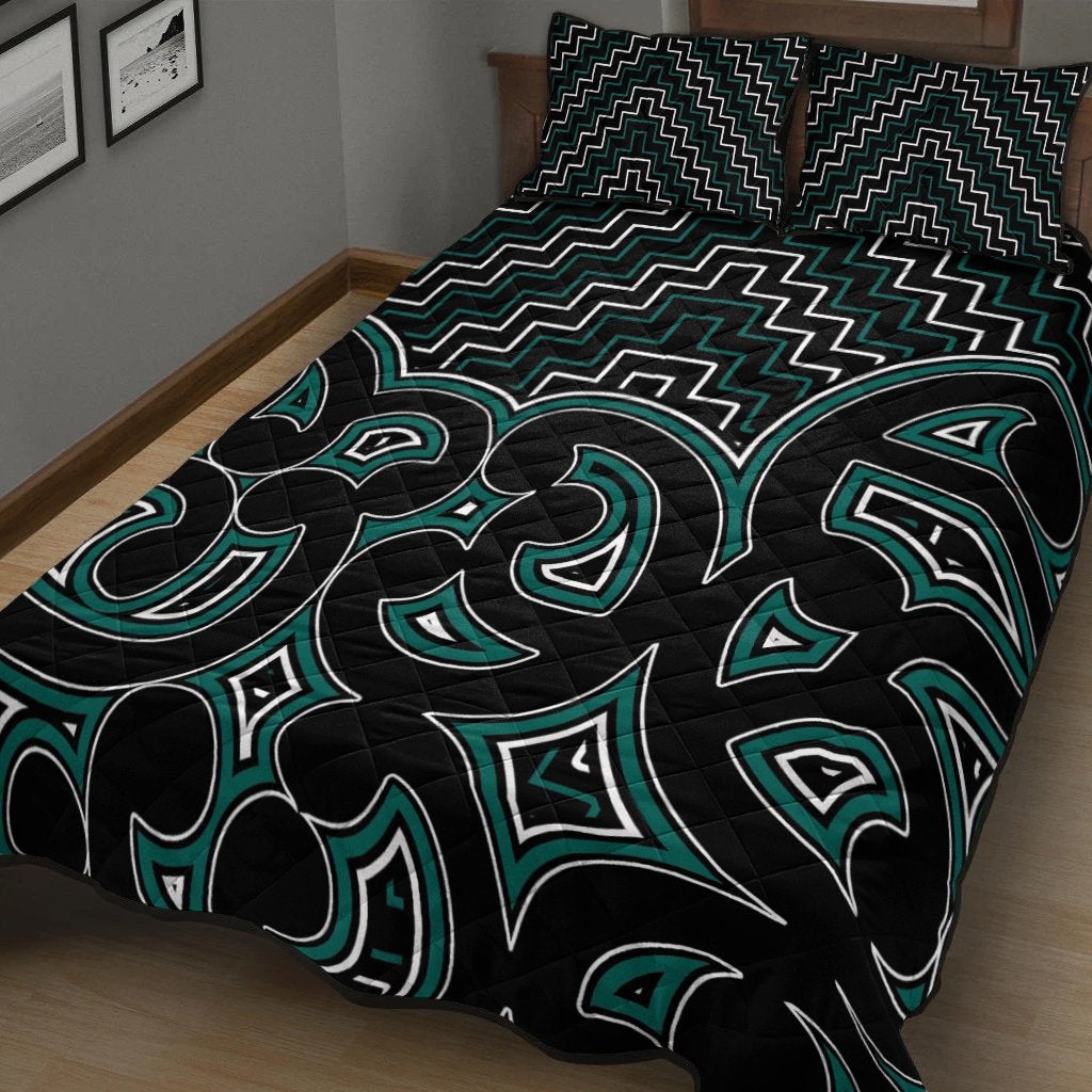 Maori graphic quilt: black with green tribal icons and zigzag pattern
