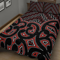 Black quilt with red-and-white Maori zigzag band and central tribal pattern blocks
