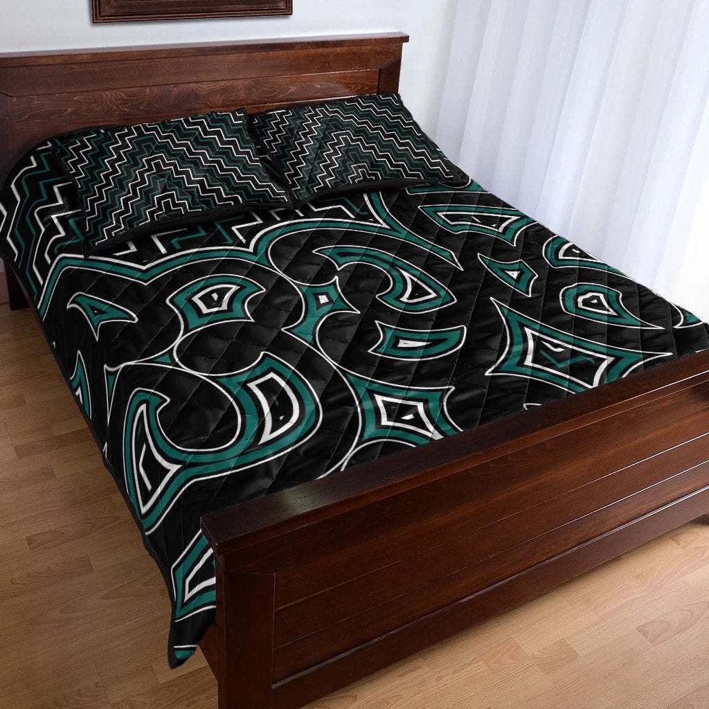 Maori-inspired quilt bed set: black fabric with green tiki-style icons