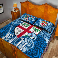 Blue quilt bed set with tapa print, central crest medallion and two coordinating pillows