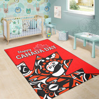 Red area rug with “Happy Canada Day” lettering and central totem-style graphic