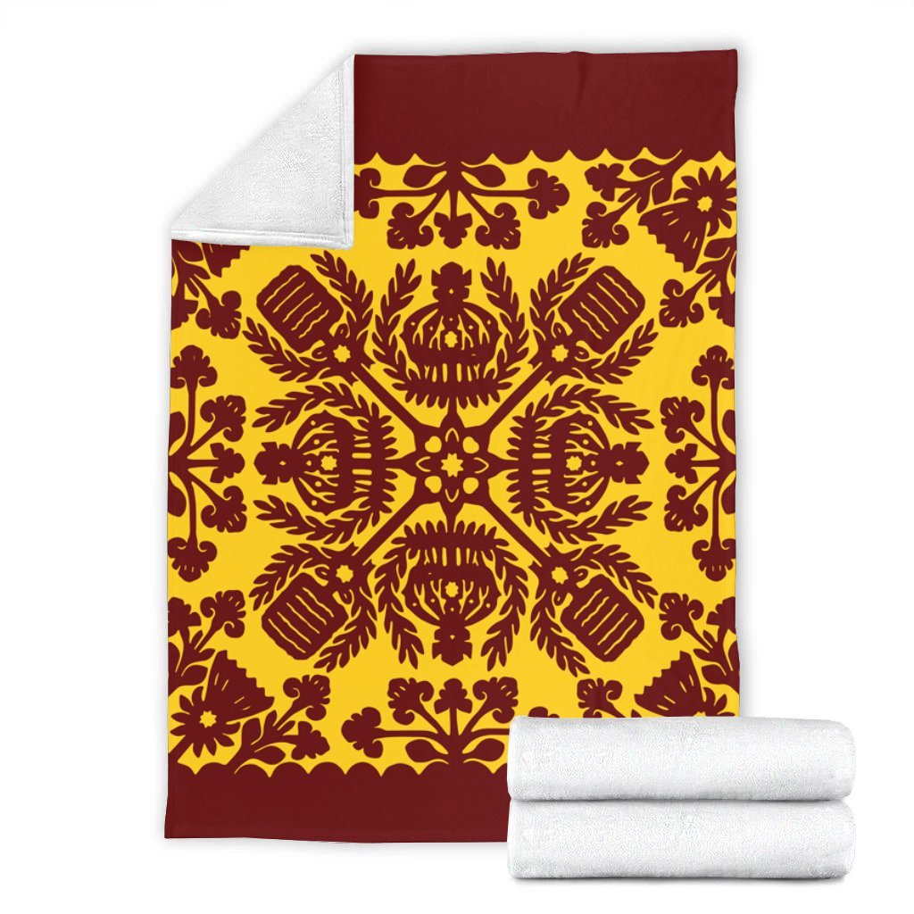Red and yellow quilt-style blanket with ornate pattern, paired with two white folded towels