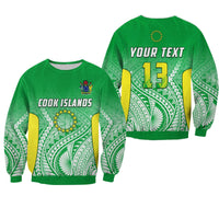 Green unisex sweatshirt with Cook Islands graphic and leaf pattern, yellow 13 on back