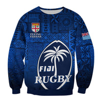 Blue tapa-pattern rugby sweatshirt with FIJI RUGBY emblem, crest, and sleeve flag detail