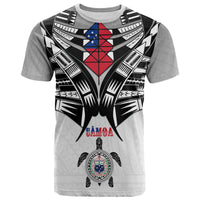 Light gray kid T-shirt with black-and-white tribal wings and red/blue emblem on front