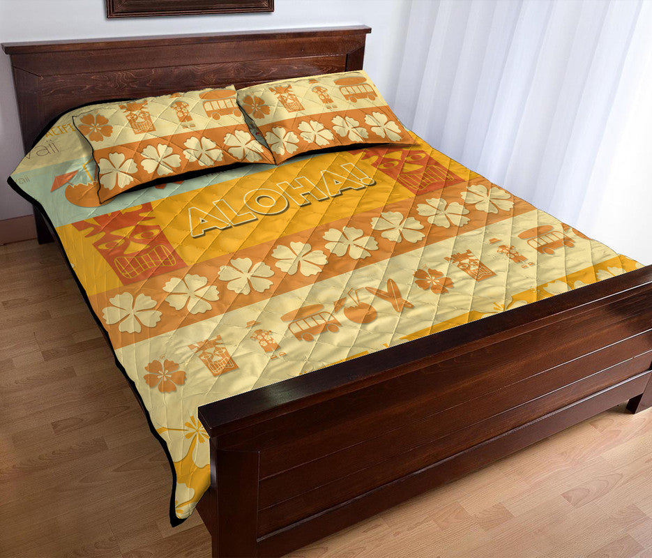 Quilt bed set quilt with ALOHA text, flowers, and surf motifs, plus matching pillows.