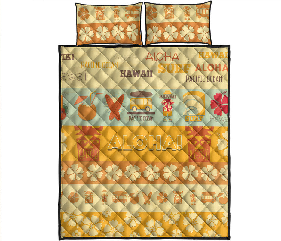Quilt bed set with yellow, orange, and cream ALOHA print and two matching pillow shams.