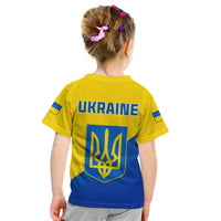 Kid back view yellow blue Ukraine-style T-shirt with “UKRAINE” and trident emblem