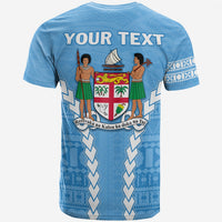 Camiseta azul con “YOUR TEXT”, escudo Fiji y dos figuras polinesias en la espalda