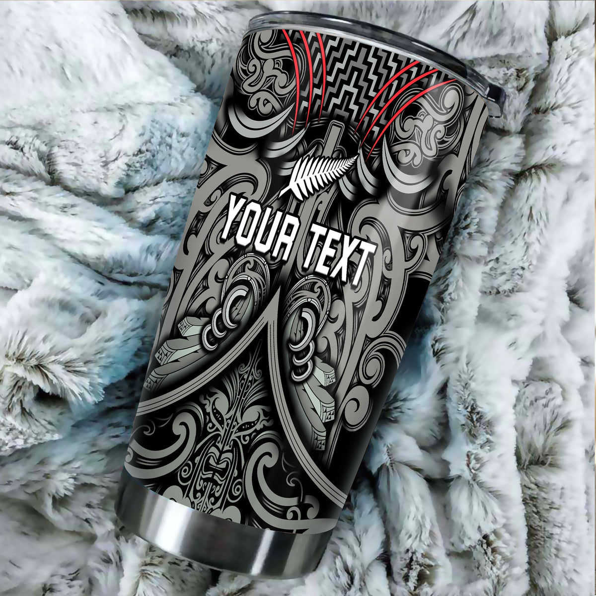 Insulated tumbler with black-and-silver Maori pattern, red accents, close-up.