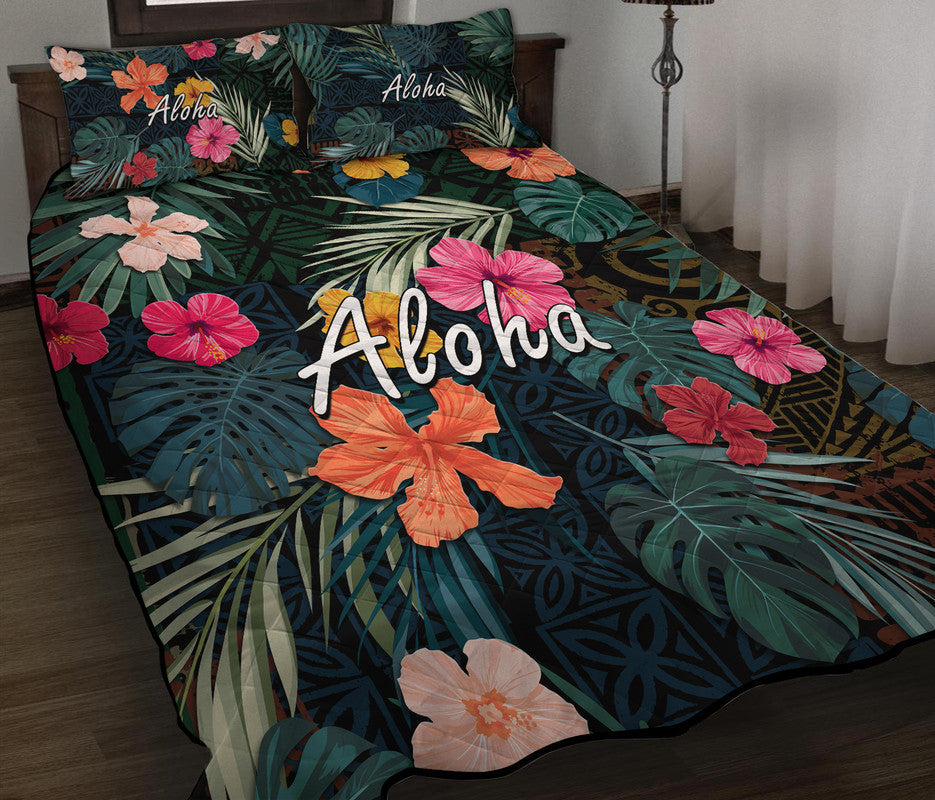 Green tropical quilt with hibiscus and large leaf patterns; Aloha script centered