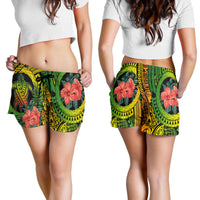Women’s tropical print shorts, green waistband with black and yellow patterns, red hibiscus