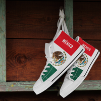 White high-top sneakers with green panels and red stripes, eagle crest and knotted laces