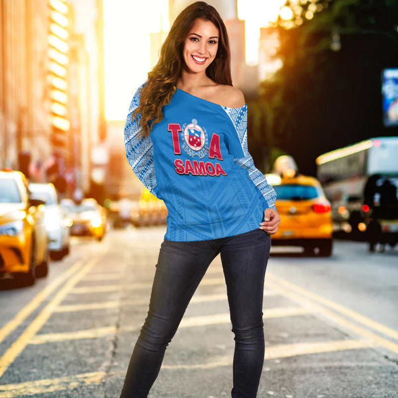 Women’s off-shoulder rugby sweater in blue with red and white crest logo, long sleeves