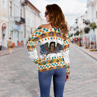 Off-shoulder white sweatshirt with colorful Ethiopian angels print, worn off one shoulder