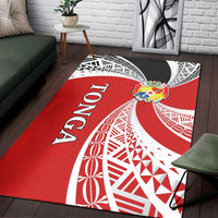 Red Tonga rug on wood floor: white crescent tapa design, 'Tonga' lettering, black border