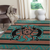 Close-up Kokopelli rug: teal and rust background with black figure and geometric banding