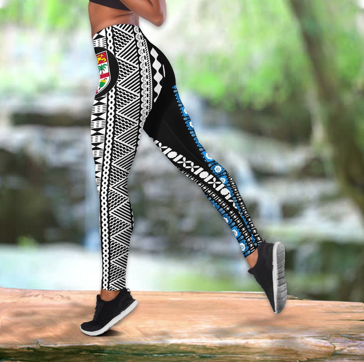 Leggings close-up: black with white geometric tapa pattern and blue side stripe