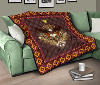 Native-style quilt on green sofa, maroon face with eagle and sun motif, diamond border