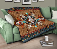 Brown quilt on couch with turquoise circles, white feather centerpiece, and multicolor geometric border