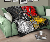 Chief Arrow quilt on green sofa, multicolor red yellow black sections with feather arrow design