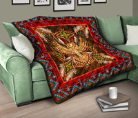 Native-style quilt on couch showing beaded owl center, red frame, and turquoise geometric border