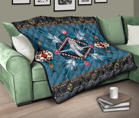 Blue Native American pattern quilt on green sofa, featuring dreamcatcher center and geometric trim.