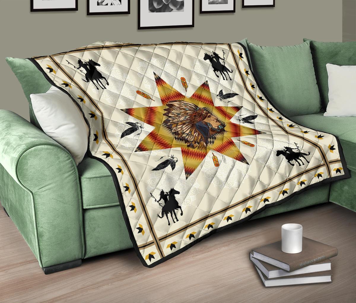 Quilt over green couch: white background, chief profile starburst, black horses and birds, gold border