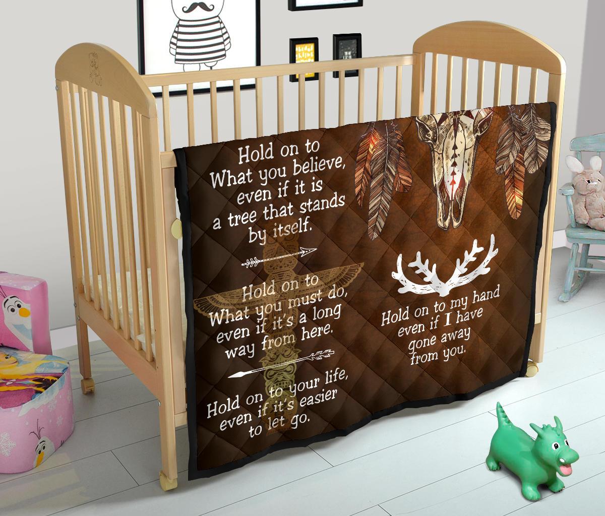 Bison feather quilt on crib: dark brown with bison head, feathers, and white poem text