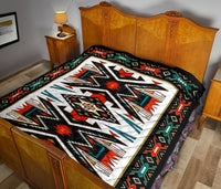 Multicolor geometric Native American quilt laid on bed, black trim around edges