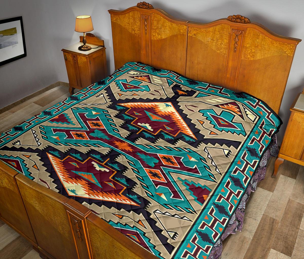 Multicolored quilt with bold geometric motifs, teal and orange accents on bed