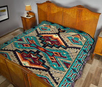 Multicolored quilt with bold geometric motifs, teal and orange accents on bed