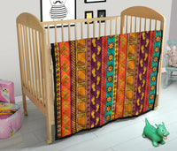 Multicolor Native-style quilt on crib, geometric stripes with foot motif print
