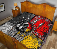 Multicolor quilt with bold red and black arrow design and yellow accents on bed