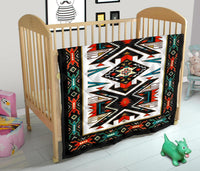 Native American design quilt draped over crib, bold multicolor geometric center