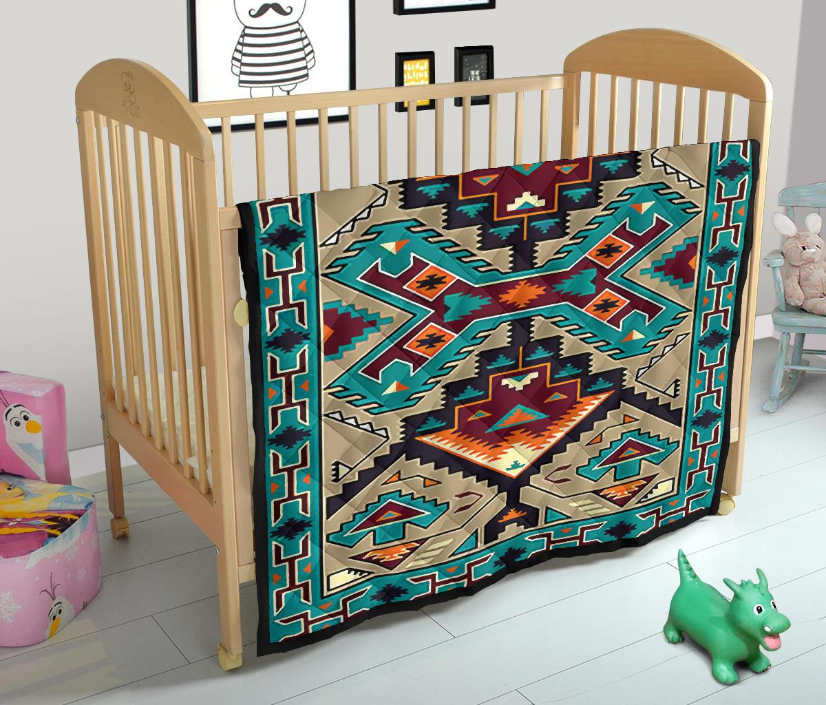 Multicolored native geometric quilt with border trim, draped over a crib