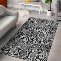 Black-and-white patterned rectangular area rug with ornate Polynesian swirls and geometric details