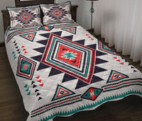 White quilt with navy/red/teal southwest diamond pattern and two matching pillow shams