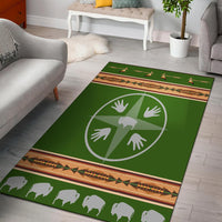 Green area rug with white medicine wheel hands and bison silhouettes, multicolor border