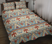 Light blue quilt bed set with red, tan, and navy geometric arrow pattern