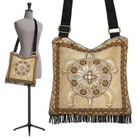Beaded tan crossbody bag with Native-style emblem, fringe hem, black adjustable strap