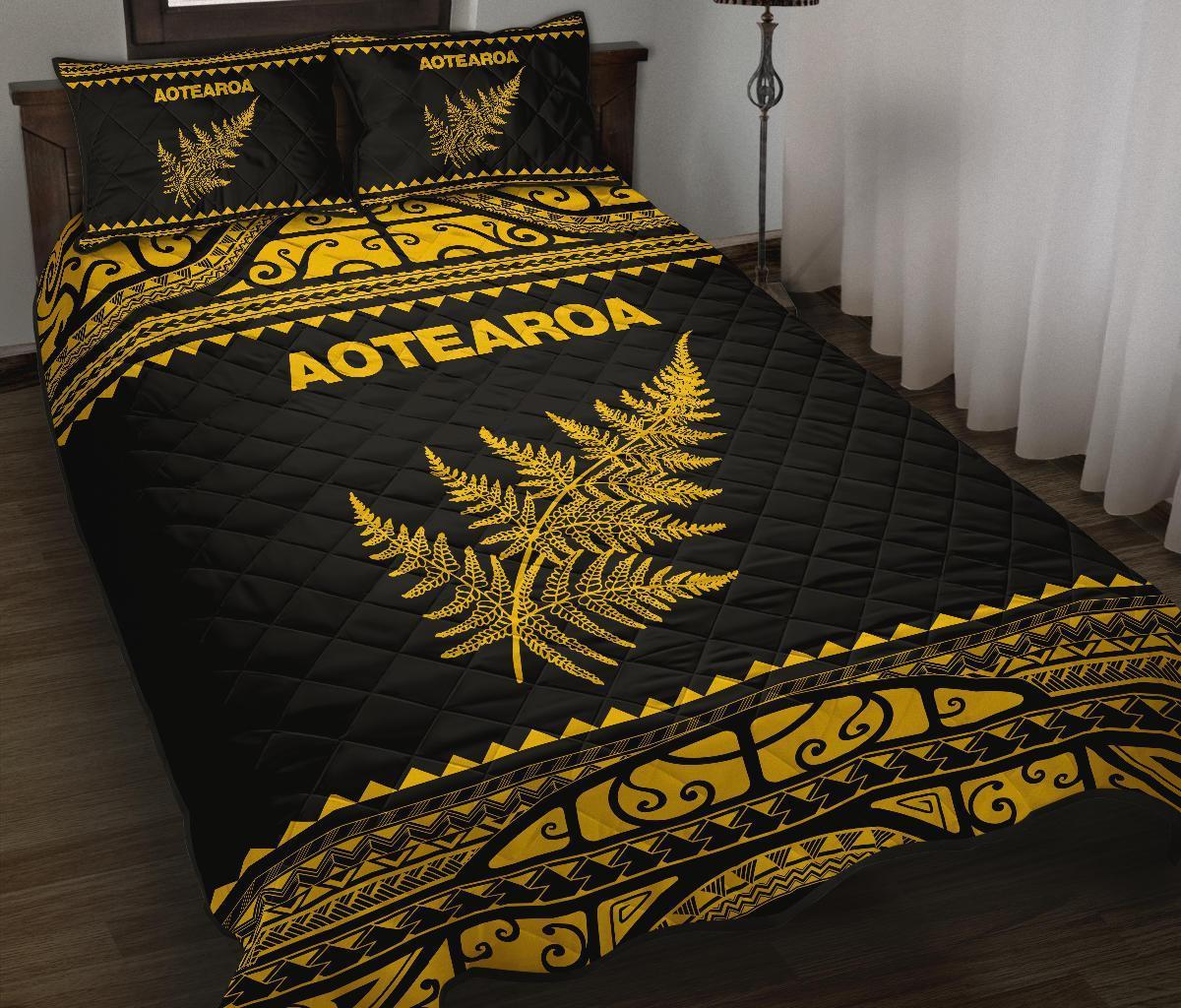 Black quilt bed set with yellow Aotearoa text, fern and Maori pattern borders