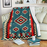 Multicolor geometric patterned blanket with bold diamond motifs and zigzag border, draped on couch