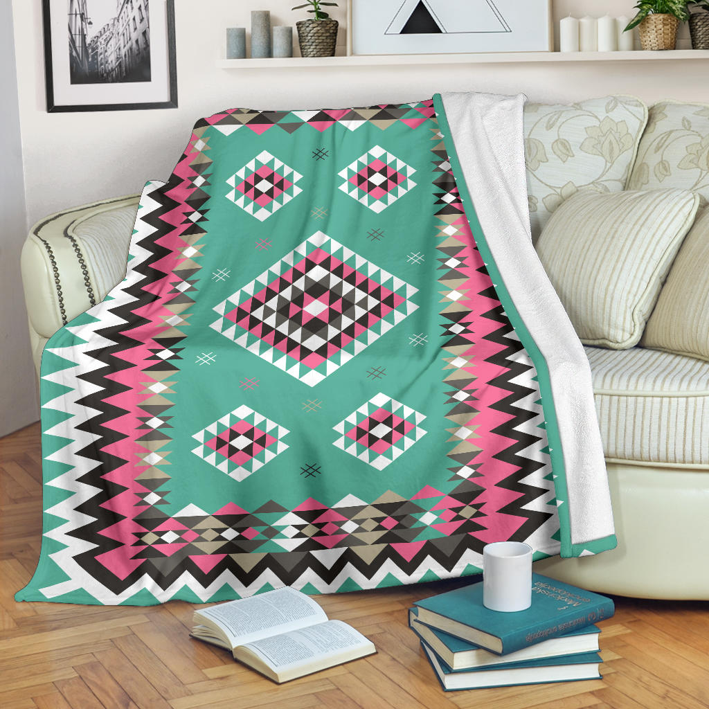 Turquoise geometric blanket with pink/black/white diamonds and zigzag border