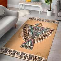 Beige area rug with native-style geometric bird and tribal patterns, black border trim