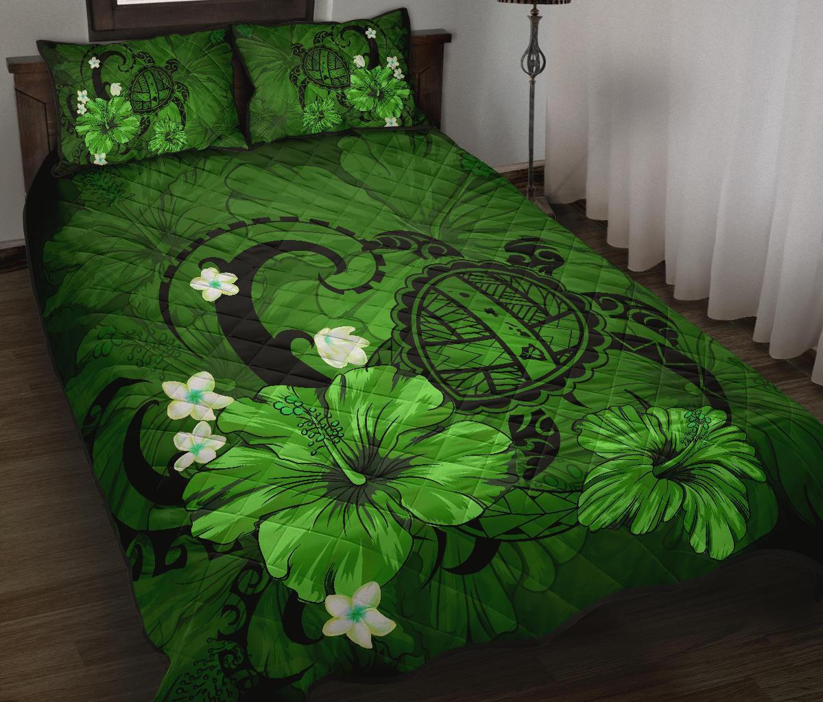 Green floral quilt and pillows with large turtle medallion and hibiscus blossoms